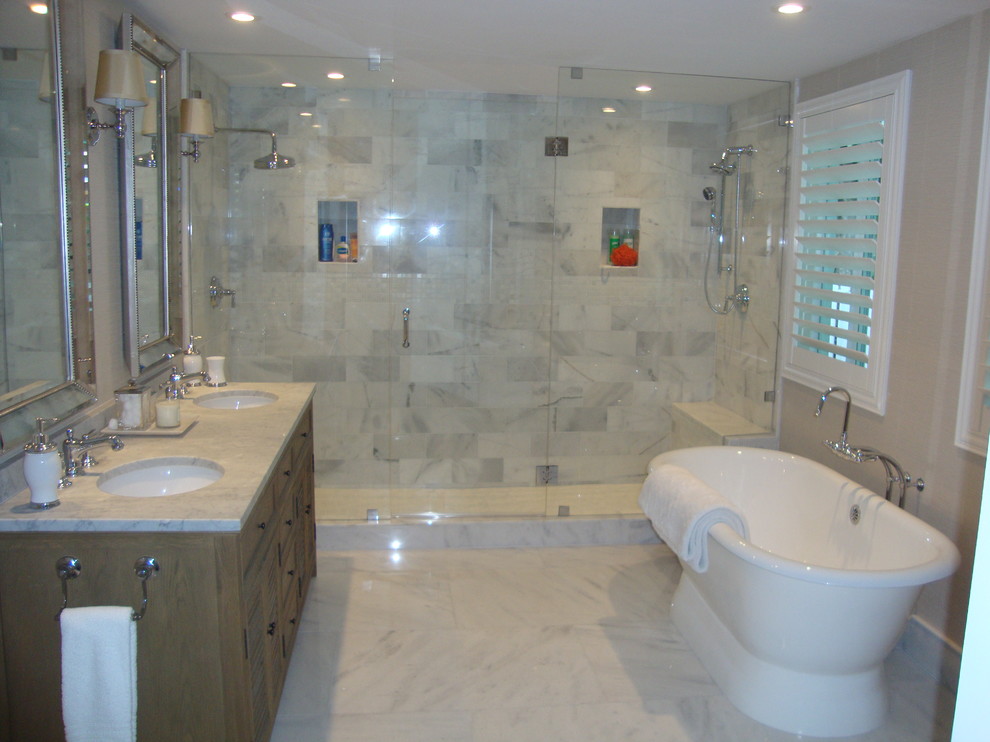 Réalisation d'une grande salle de bain principale tradition en bois foncé avec une baignoire indépendante, une douche double, un carrelage gris, du carrelage en marbre, un mur beige, un sol en marbre, un lavabo encastré et un plan de toilette en marbre.