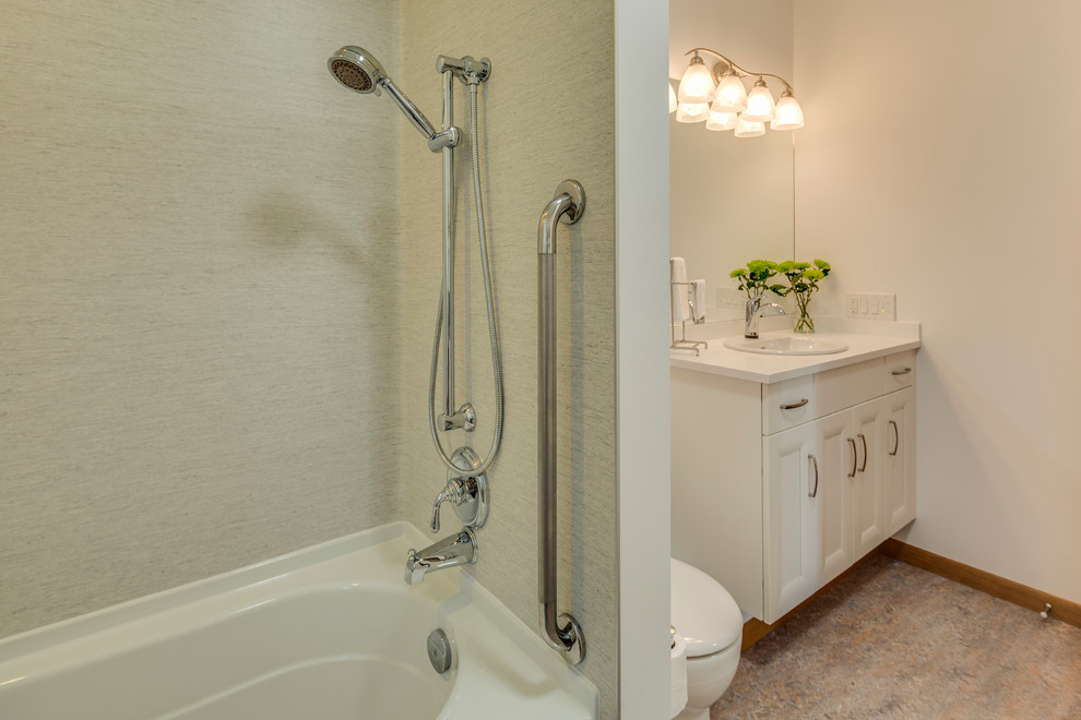 Photo of a medium sized classic ensuite bathroom in Vancouver with a built-in sink, recessed-panel cabinets, white cabinets, an alcove bath, a two-piece toilet and white walls.