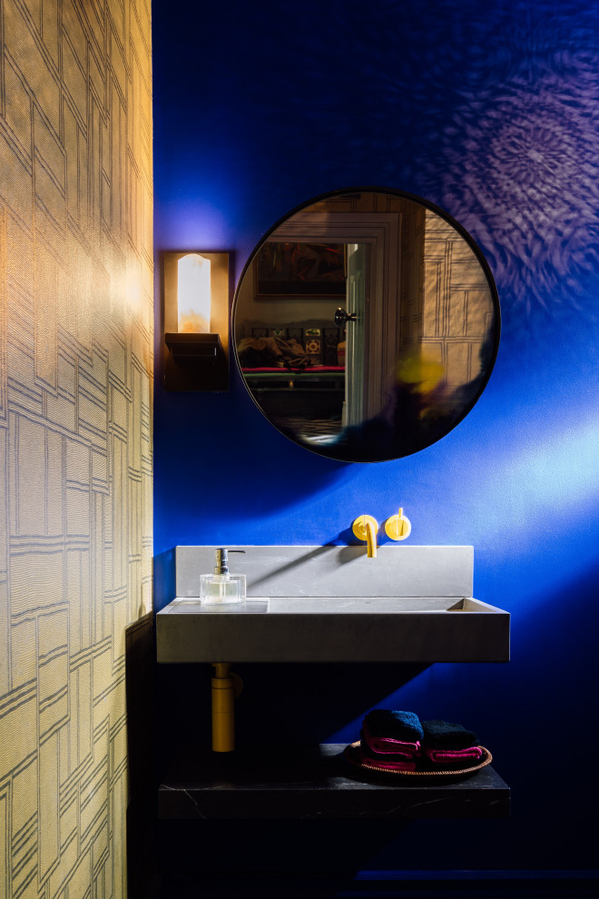 Imagen de cuarto de baño único bohemio con sanitario de pared, paredes azules, lavabo suspendido y papel pintado