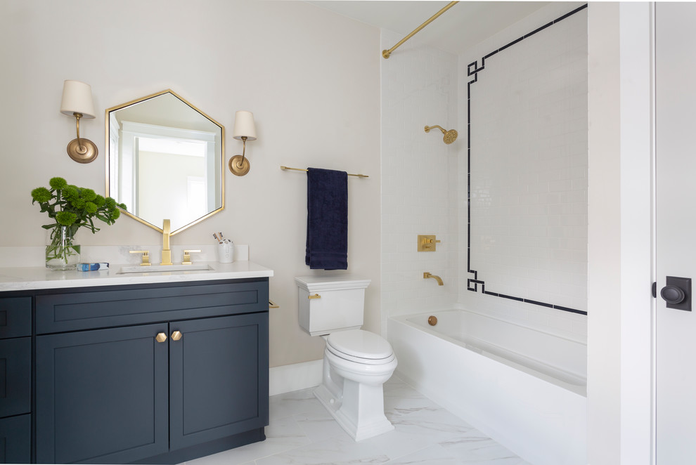 Exempel på ett stort klassiskt vit vitt badrum, med släta luckor, blå skåp, ett badkar i en alkov, en dubbeldusch, en toalettstol med separat cisternkåpa, grå kakel, vita väggar, marmorgolv, ett undermonterad handfat, bänkskiva i kvartsit och vitt golv