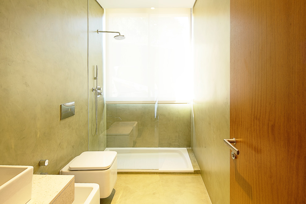 Ejemplo de cuarto de baño contemporáneo pequeño con ducha abierta, sanitario de pared, paredes beige, aseo y ducha y lavabo sobreencimera