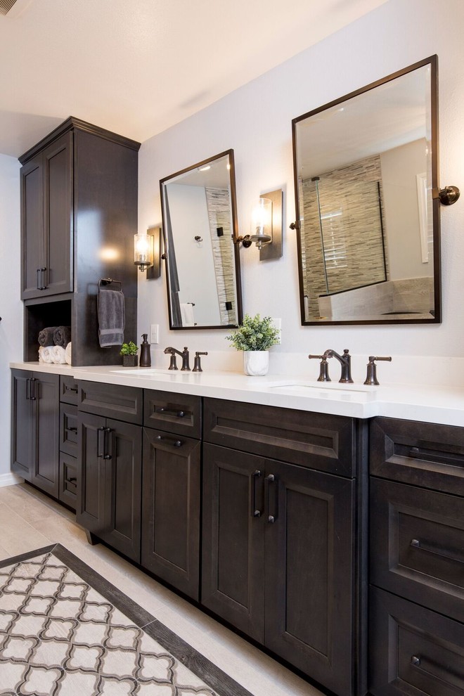 Photo of a large mediterranean ensuite bathroom in Los Angeles with recessed-panel cabinets, dark wood cabinets, a freestanding bath, a corner shower, beige tiles, porcelain tiles, grey walls, porcelain flooring, a submerged sink, engineered stone worktops, beige floors, a hinged door and white worktops.