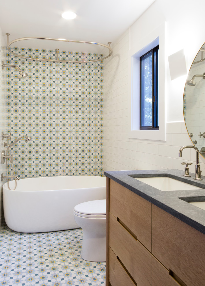 Источник вдохновения для домашнего уюта: детская ванная комната среднего размера в стиле неоклассика (современная классика) с фасадами островного типа, светлыми деревянными фасадами, отдельно стоящей ванной, душем над ванной, унитазом-моноблоком, разноцветной плиткой, цементной плиткой, разноцветными стенами, полом из цементной плитки, накладной раковиной, столешницей из талькохлорита, разноцветным полом, шторкой для ванной и серой столешницей