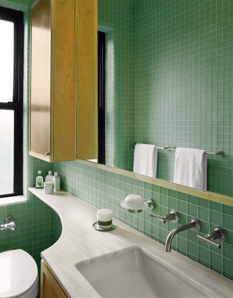 Alcove shower - small modern master green tile and glass tile alcove shower idea in New York with an undermount sink, recessed-panel cabinets, light wood cabinets, marble countertops, a wall-mount toilet and green walls