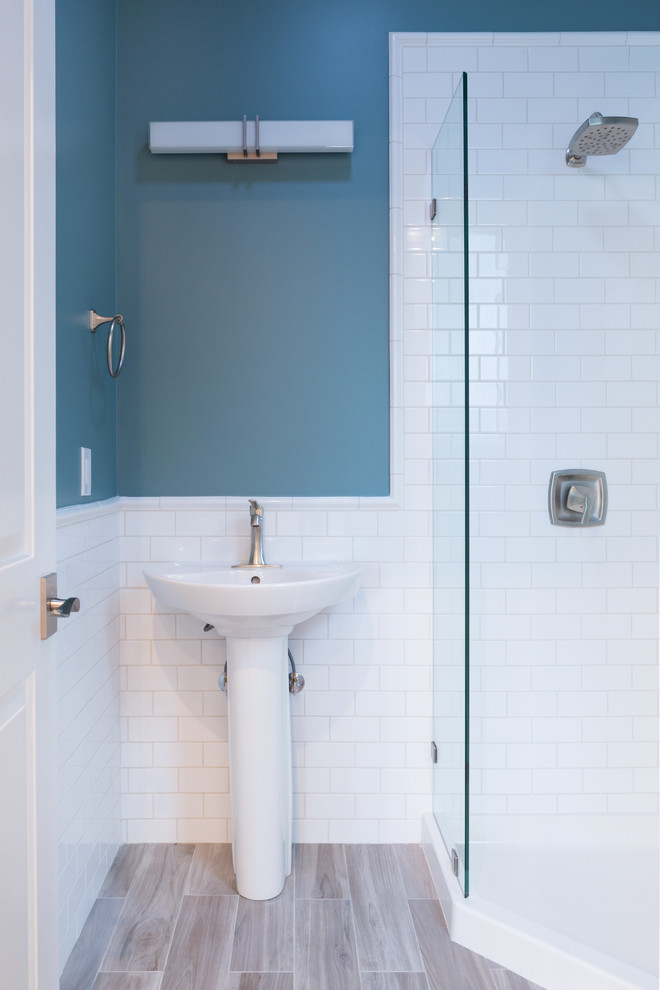 Inspiration for a mid-sized contemporary 3/4 white tile and subway tile laminate floor and beige floor corner shower remodel in San Francisco with blue walls, a pedestal sink and a hinged shower door