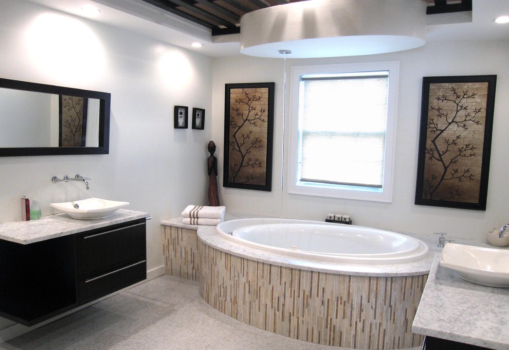 Пример оригинального дизайна: главная ванная комната среднего размера в современном стиле с настольной раковиной, плоскими фасадами, черными фасадами, накладной ванной, белыми стенами, полом из мозаичной плитки, мраморной столешницей и серым полом