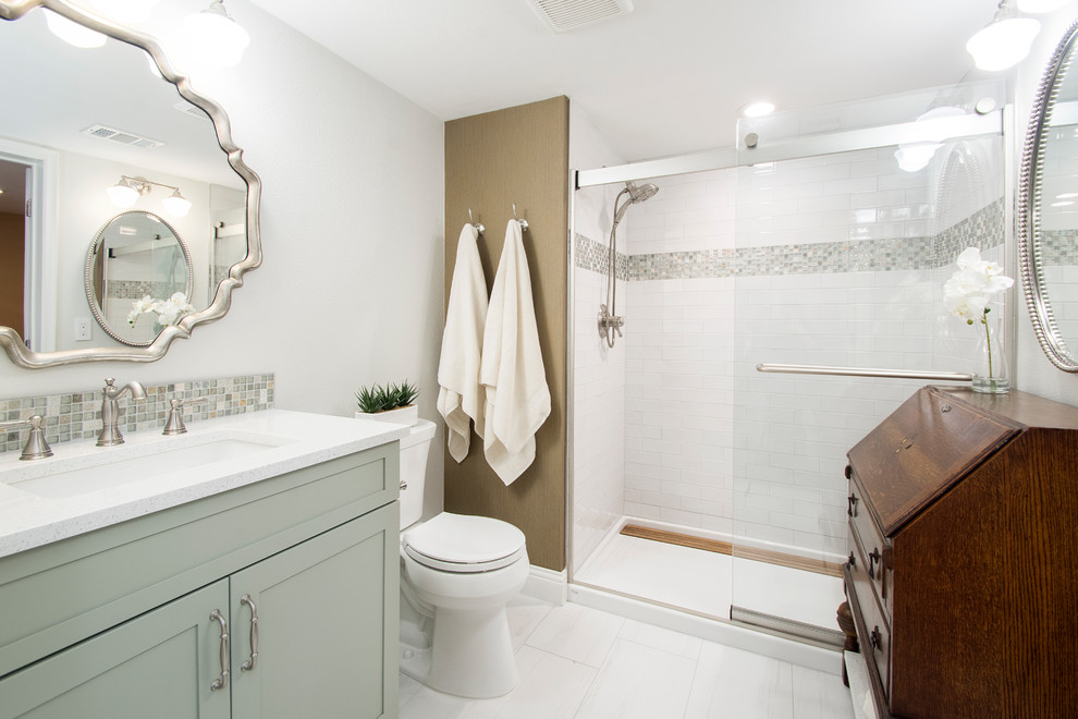 Пример оригинального дизайна: ванная комната среднего размера в стиле неоклассика (современная классика) с плоскими фасадами, зелеными фасадами, двойным душем, раздельным унитазом, белой плиткой, керамогранитной плиткой, серыми стенами, полом из керамогранита, душевой кабиной, врезной раковиной, белым полом и душем с раздвижными дверями