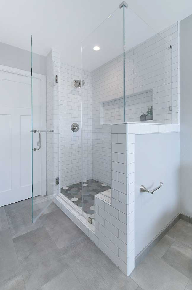 На фото: главная ванная комната среднего размера в стиле неоклассика (современная классика) с белыми фасадами, отдельно стоящей ванной, душем в нише, раздельным унитазом, белой плиткой, плиткой кабанчик, серыми стенами, полом из керамогранита, врезной раковиной, столешницей из искусственного кварца, серым полом, душем с распашными дверями, белой столешницей, тумбой под одну раковину и сиденьем для душа