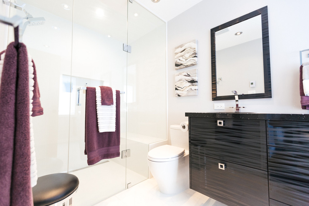 Esempio di una stanza da bagno padronale contemporanea di medie dimensioni con ante lisce, ante nere, doccia a filo pavimento, WC monopezzo, piastrelle bianche, piastrelle di vetro, pareti bianche, pavimento in marmo, lavabo sottopiano e top in granito