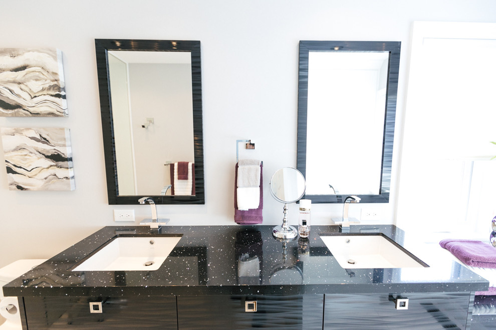 Modern inredning av ett mellanstort en-suite badrum, med släta luckor, svarta skåp, en kantlös dusch, en toalettstol med hel cisternkåpa, vit kakel, glaskakel, vita väggar, marmorgolv, ett undermonterad handfat och granitbänkskiva