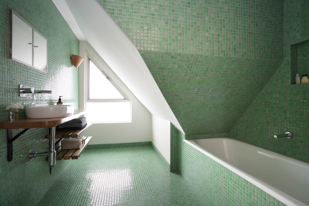 На фото: маленькая главная ванная комната в современном стиле с настольной раковиной, открытыми фасадами, столешницей из дерева, накладной ванной, зеленой плиткой, плиткой мозаикой, зелеными стенами, полом из мозаичной плитки, коричневой столешницей, коричневыми фасадами, душем над ванной, унитазом-моноблоком, зеленым полом и душем с распашными дверями для на участке и в саду с