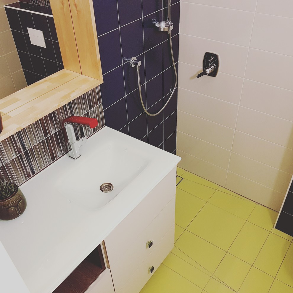 На фото: маленькая ванная комната в стиле неоклассика (современная классика) с плоскими фасадами, бежевыми фасадами, угловым душем, инсталляцией, разноцветной плиткой, керамогранитной плиткой, разноцветными стенами, полом из керамогранита, душевой кабиной, настольной раковиной, стеклянной столешницей, желтым полом и душем с распашными дверями для на участке и в саду