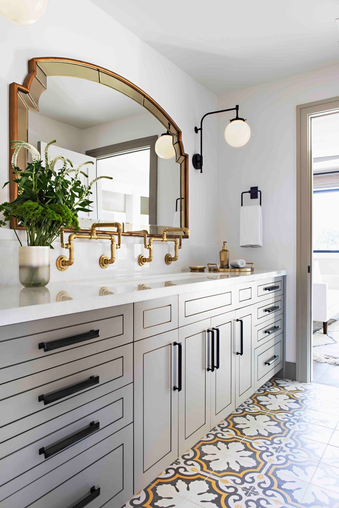 Modelo de cuarto de baño principal clásico renovado con puertas de armario grises, paredes blancas, lavabo de seno grande, suelo multicolor y encimeras blancas