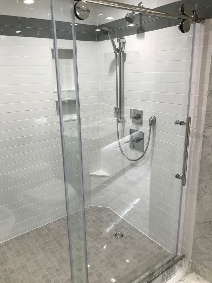 Exemple d'une grande douche en alcôve principale tendance avec un carrelage blanc, des carreaux de céramique et une cabine de douche à porte coulissante.