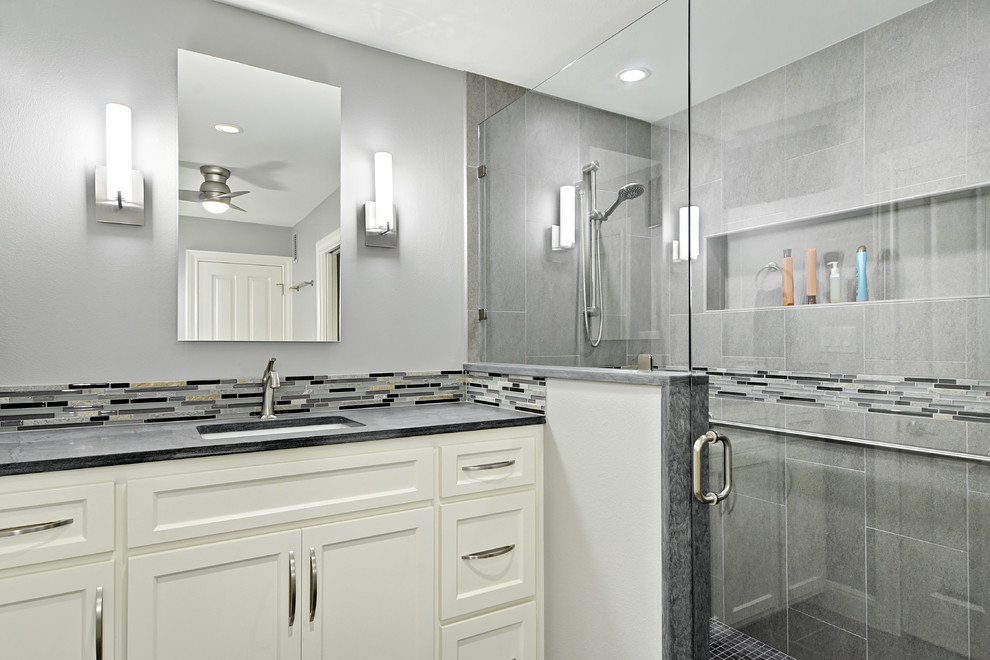Corner shower - small transitional gray tile and porcelain tile porcelain tile corner shower idea in Austin with an undermount sink, recessed-panel cabinets, white cabinets, quartzite countertops and gray walls