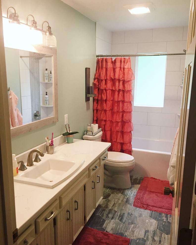 Idéer för små lantliga vitt badrum för barn, med luckor med infälld panel, vita skåp, ett platsbyggt badkar, en dusch/badkar-kombination, en toalettstol med separat cisternkåpa, vit kakel, porslinskakel, blå väggar, klinkergolv i porslin, ett nedsänkt handfat, granitbänkskiva, grått golv och dusch med duschdraperi