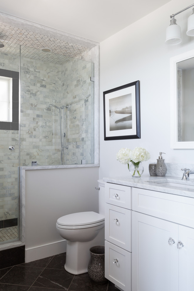 Inspiration for a small contemporary ensuite bathroom in Boston with shaker cabinets, white cabinets, an alcove shower, a two-piece toilet, grey tiles, white tiles, marble tiles, white walls, slate flooring, a submerged sink, marble worktops, black floors and a hinged door.