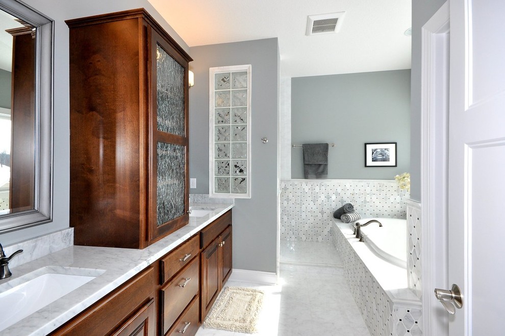 Example of a mid-sized classic master gray tile and marble tile marble floor and gray floor bathroom design in Minneapolis with raised-panel cabinets, dark wood cabinets, gray walls, an undermount sink, marble countertops and gray countertops
