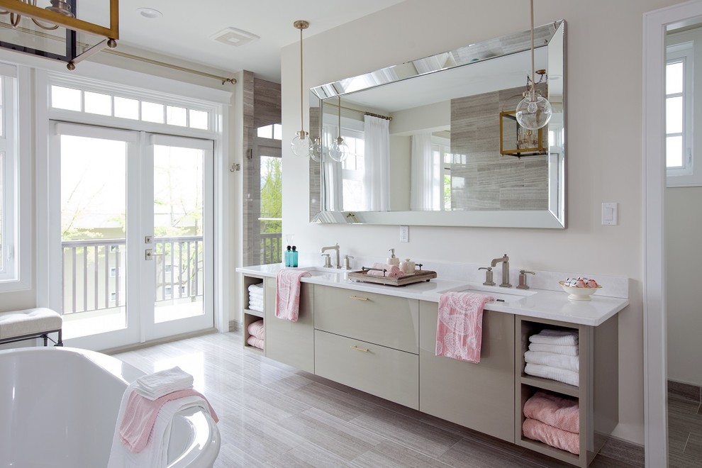 Idee per una stanza da bagno chic con lavabo sottopiano, ante lisce, ante grigie, vasca freestanding e pareti beige