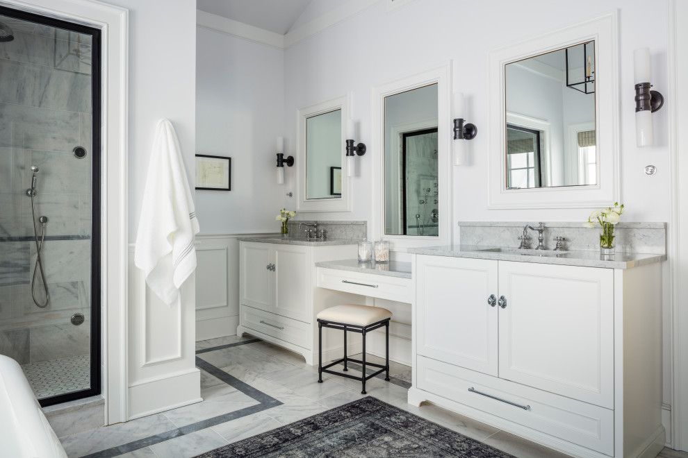 Example of a beach style gray floor, double-sink, vaulted ceiling and wainscoting bathroom design in Seattle with recessed-panel cabinets, white cabinets, white walls, an undermount sink, white countertops and a built-in vanity