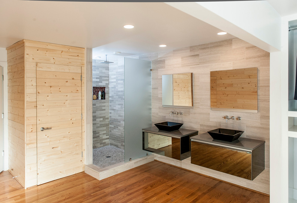 Источник вдохновения для домашнего уюта: главная ванная комната в современном стиле с стеклянными фасадами, серыми фасадами, угловым душем, серой плиткой, керамогранитной плиткой, серыми стенами, паркетным полом среднего тона, настольной раковиной, столешницей из искусственного камня, коричневым полом и открытым душем