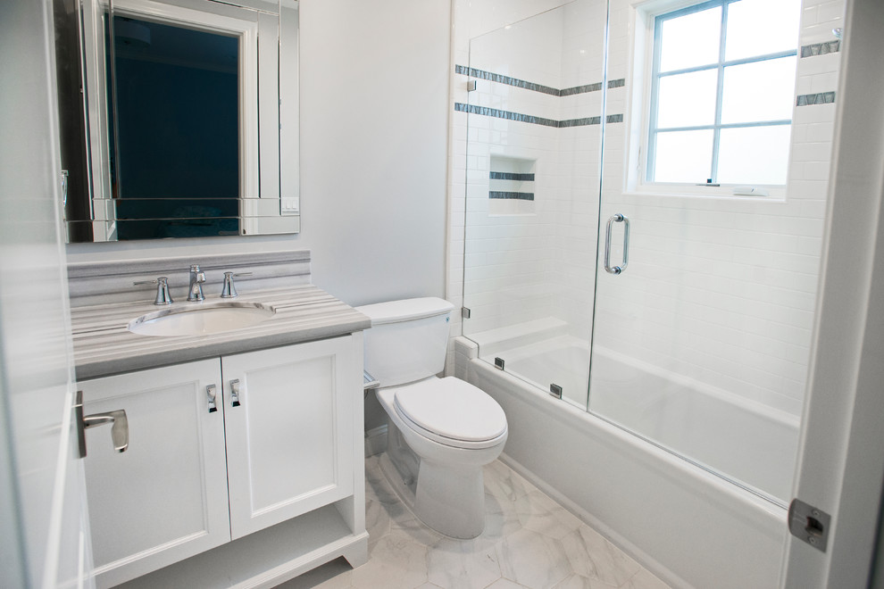 Small contemporary shower room bathroom in Los Angeles with recessed-panel cabinets, white cabinets, a shower/bath combination, a two-piece toilet, grey tiles, white tiles, metro tiles, grey walls, marble flooring, a submerged sink and marble worktops.