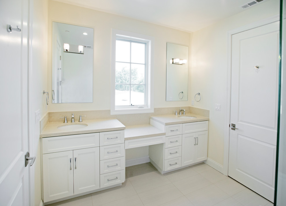 This is an example of a medium sized contemporary ensuite bathroom in Los Angeles with recessed-panel cabinets, white cabinets, beige walls, ceramic flooring, a submerged sink and solid surface worktops.