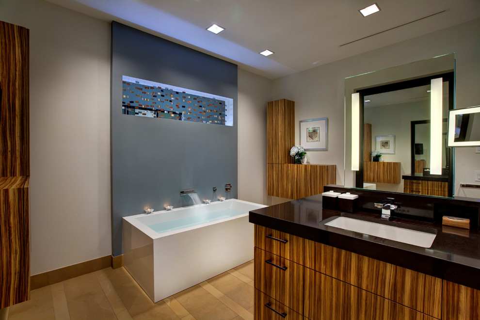 Foto di una stanza da bagno minimal con lavabo sottopiano, ante lisce, ante in legno scuro, pareti beige e pavimento con piastrelle in ceramica