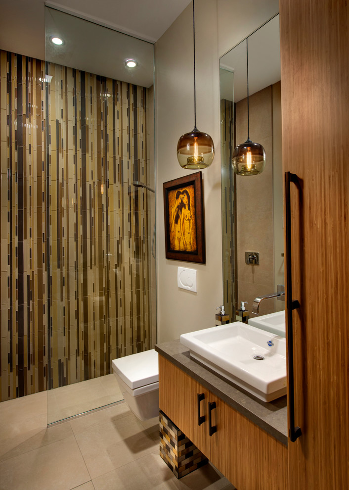 Imagen de cuarto de baño contemporáneo con lavabo sobreencimera, armarios con paneles lisos, puertas de armario de madera oscura, ducha a ras de suelo, sanitario de pared, baldosas y/o azulejos multicolor, baldosas y/o azulejos en mosaico, paredes beige y aseo y ducha