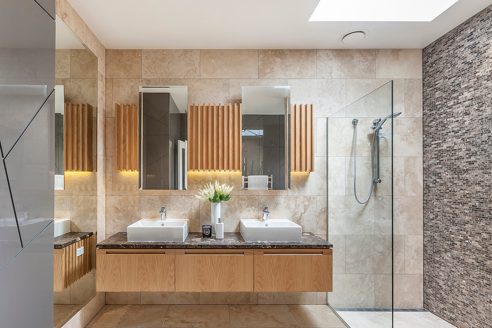 Inspiration for a large contemporary bathroom in Auckland with light wood cabinets, a walk-in shower, beige tiles, stone slabs, travertine flooring, a vessel sink, marble worktops and an open shower.
