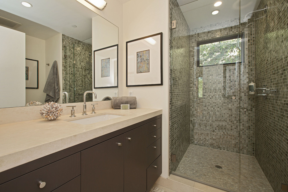 Photo of a small contemporary bathroom in San Francisco with a submerged sink, flat-panel cabinets, dark wood cabinets, limestone worktops, an alcove shower, green tiles, pebble tile flooring, mosaic tiles and white walls.