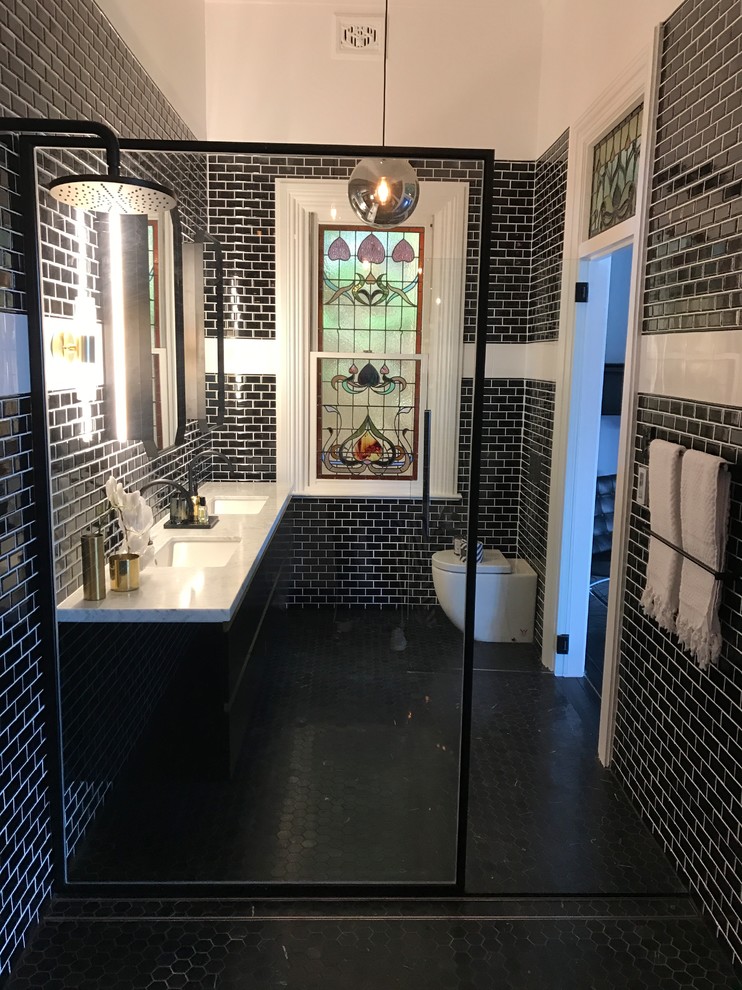 На фото: огромная главная ванная комната в викторианском стиле с черными фасадами, инсталляцией, черно-белой плиткой, плиткой кабанчик, мраморным полом, врезной раковиной, мраморной столешницей и черным полом