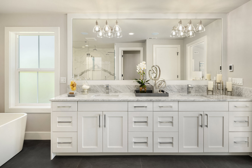 Photo of a farmhouse bathroom in Seattle with shaker cabinets, white cabinets, grey walls, a submerged sink, grey floors, grey worktops and double sinks.