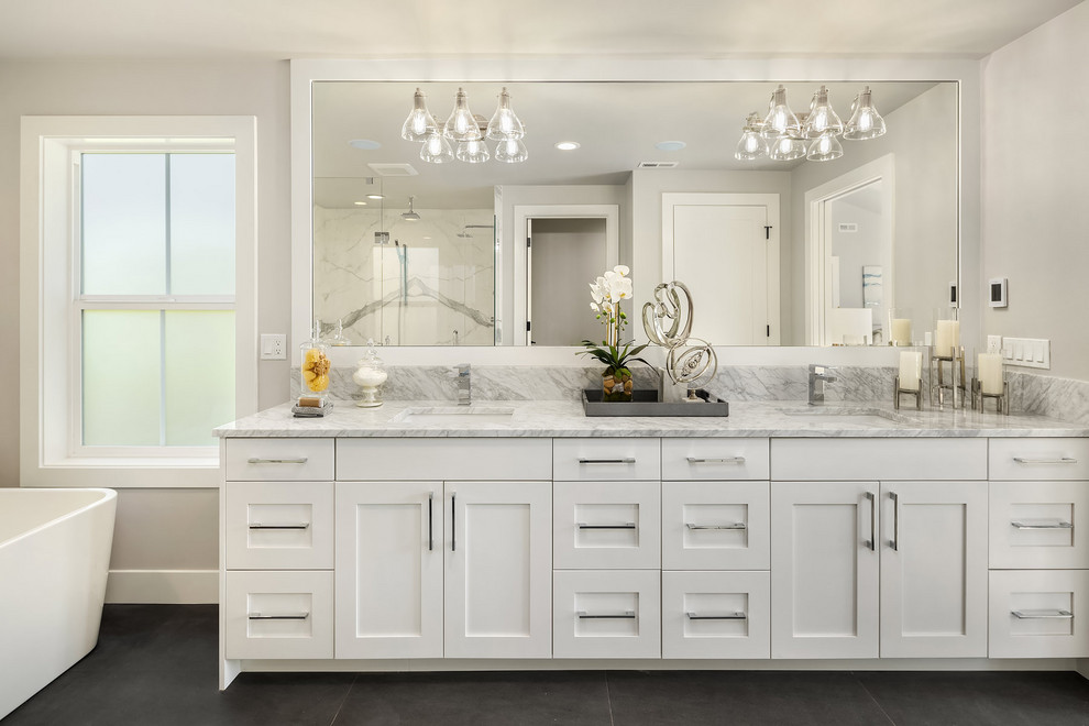 Idée de décoration pour une salle de bain champêtre avec un placard à porte shaker, des portes de placard blanches, un mur gris, un lavabo encastré, un sol gris, un plan de toilette gris et meuble double vasque.