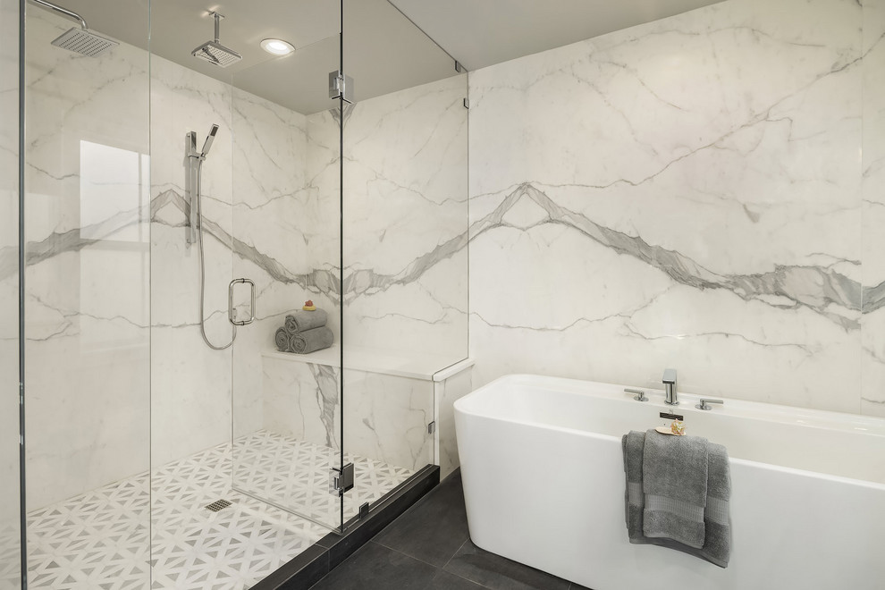 Lantlig inredning av ett badrum, med ett fristående badkar, vit kakel, stenhäll och grått golv