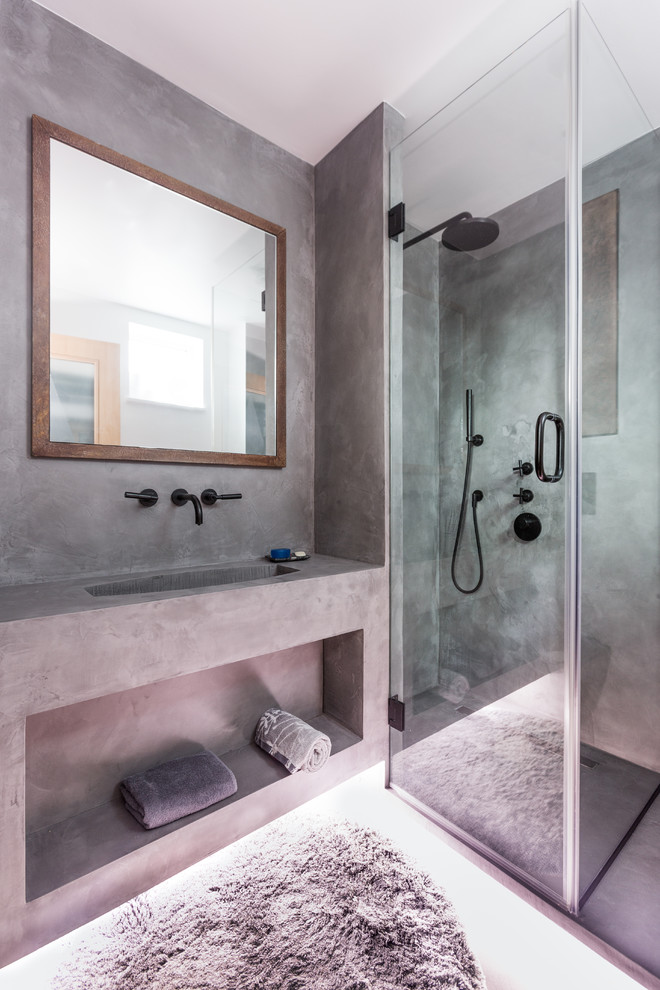 Inspiration pour une petite salle de bain principale urbaine avec un placard à porte affleurante, des portes de placard marrons, une douche ouverte, WC suspendus, un carrelage gris, un mur gris, sol en béton ciré, un lavabo suspendu, un sol gris et une cabine de douche à porte battante.
