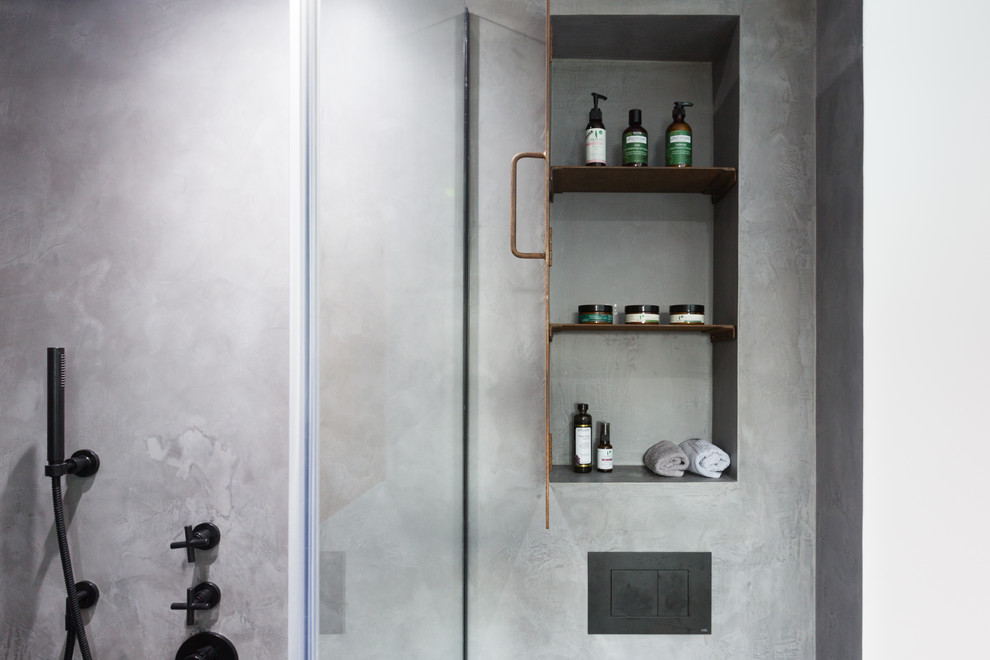 Idéer för att renovera ett litet industriellt en-suite badrum, med luckor med profilerade fronter, bruna skåp, en öppen dusch, en vägghängd toalettstol, grå kakel, grå väggar, betonggolv, ett väggmonterat handfat, grått golv och dusch med gångjärnsdörr