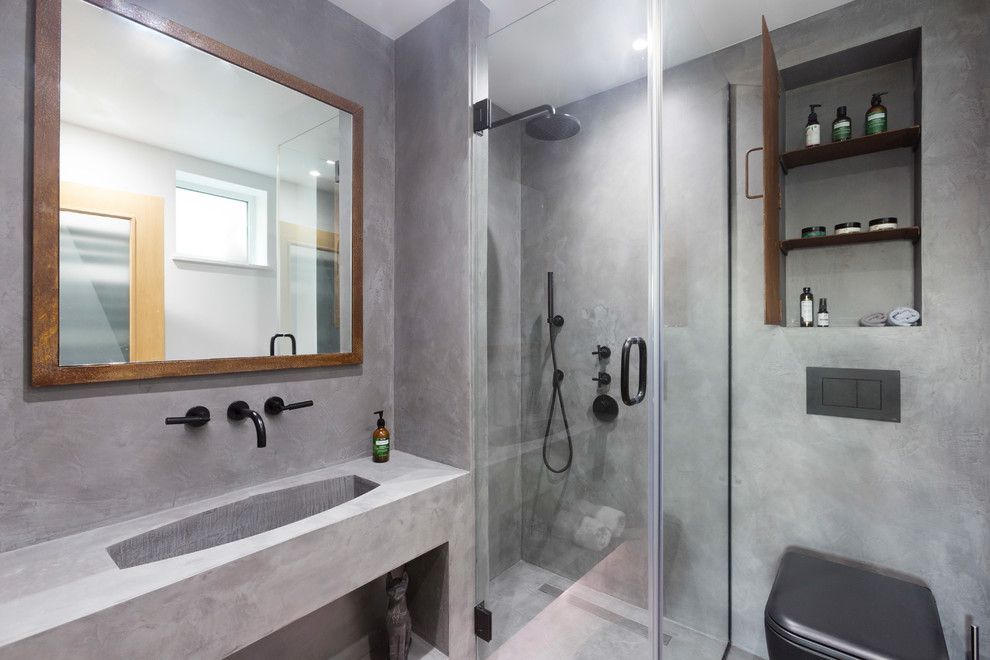 Inspiration for a small industrial ensuite bathroom in London with beaded cabinets, brown cabinets, a walk-in shower, a wall mounted toilet, grey tiles, grey walls, concrete flooring, a wall-mounted sink, grey floors and a hinged door.