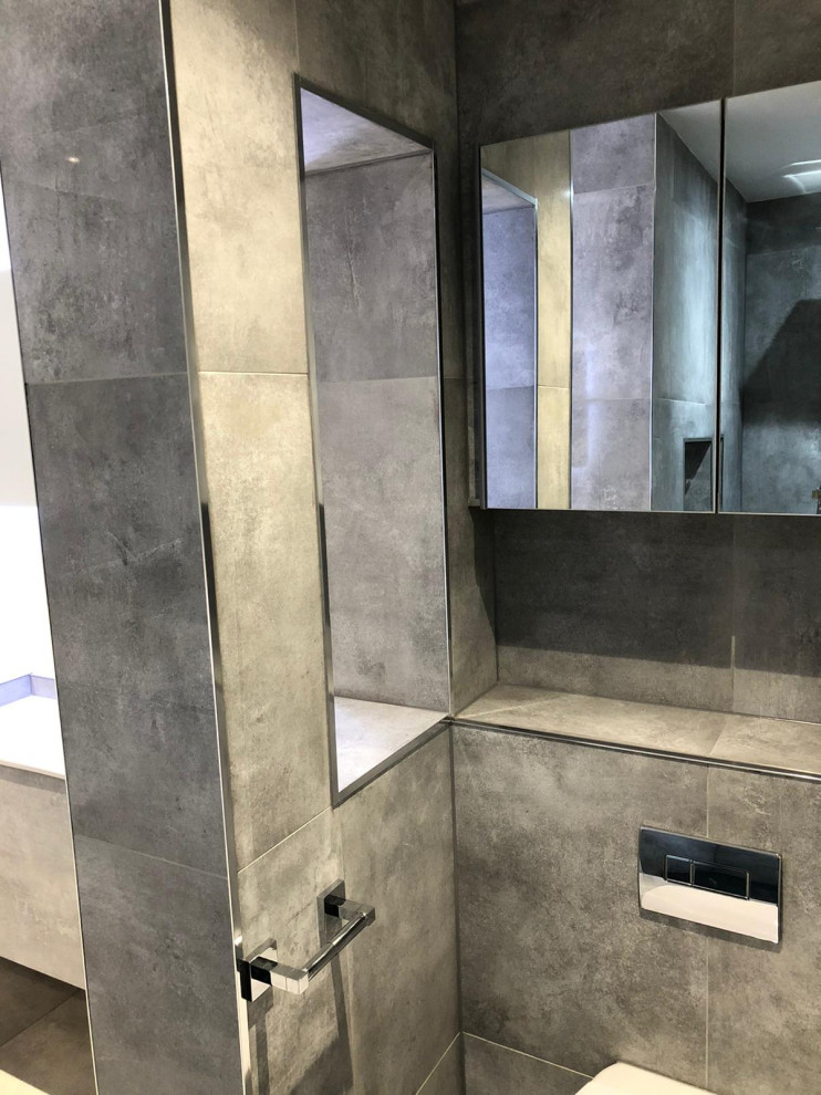 Foto di una stanza da bagno minimalista con ante grigie, vasca freestanding, doccia aperta, WC monopezzo, piastrelle grigie, piastrelle in gres porcellanato, pavimento in gres porcellanato, top piastrellato, pavimento grigio e top grigio