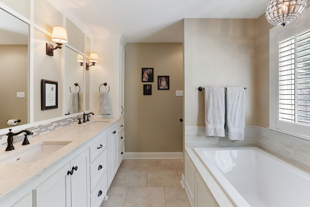 Inspiration for a transitional multicolored tile ceramic tile and white floor bathroom remodel in New Orleans with shaker cabinets, white cabinets, white walls, an undermount sink, quartz countertops and a hinged shower door