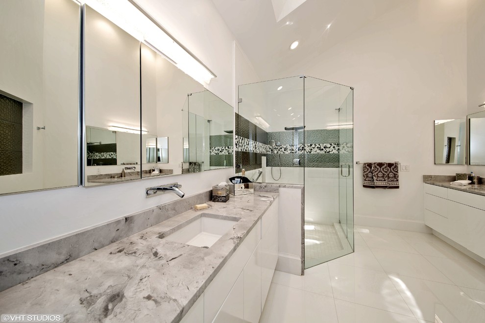 На фото: главная ванная комната в стиле модернизм с плоскими фасадами, белыми фасадами, мраморной столешницей, галечной плиткой, серыми стенами, полом из керамогранита, врезной раковиной, угловым душем и серой плиткой с