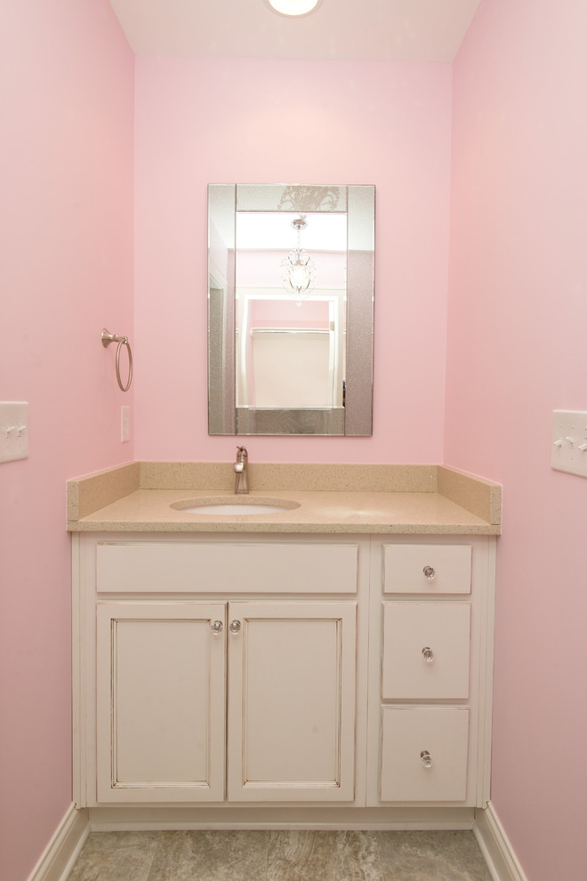 Idéer för ett mellanstort klassiskt badrum för barn, med luckor med profilerade fronter, vita skåp, en toalettstol med separat cisternkåpa, beige kakel, keramikplattor, rosa väggar, klinkergolv i keramik, ett undermonterad handfat och laminatbänkskiva