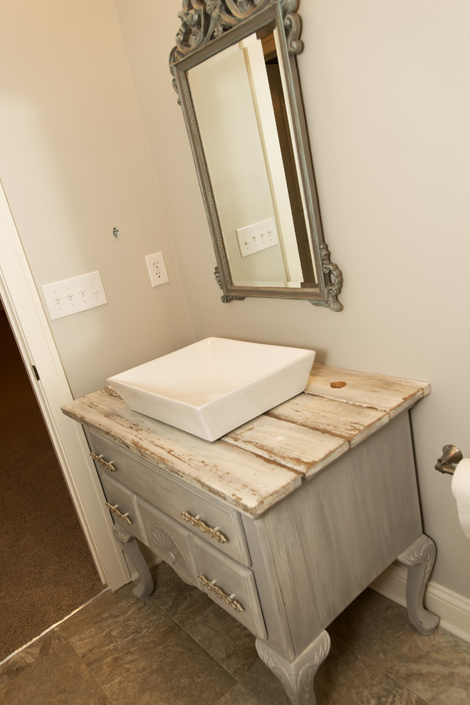 Example of a mid-sized transitional gray tile and ceramic tile ceramic tile bathroom design in Indianapolis with furniture-like cabinets, gray cabinets, beige walls, a vessel sink and wood countertops