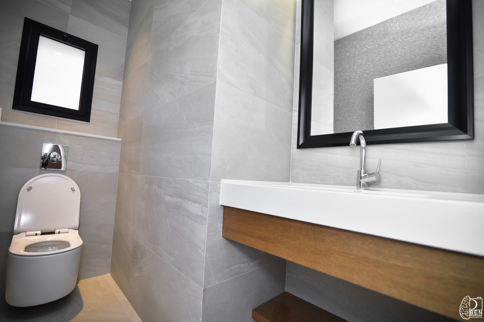 Immagine di una stanza da bagno con doccia minimal di medie dimensioni con WC sospeso, pavimento in gres porcellanato, lavabo sottopiano, pavimento grigio e top bianco