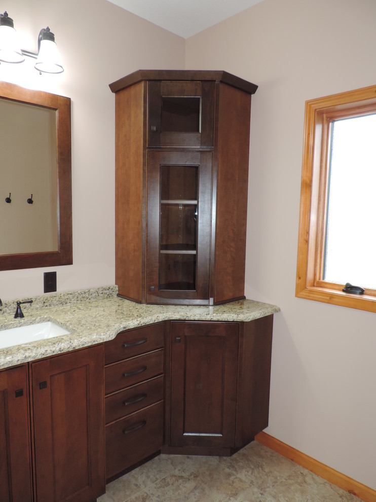 Amerikansk inredning av ett mellanstort beige beige badrum med dusch, med luckor med upphöjd panel, skåp i mellenmörkt trä, beige väggar, klinkergolv i keramik, ett undermonterad handfat, granitbänkskiva och beiget golv