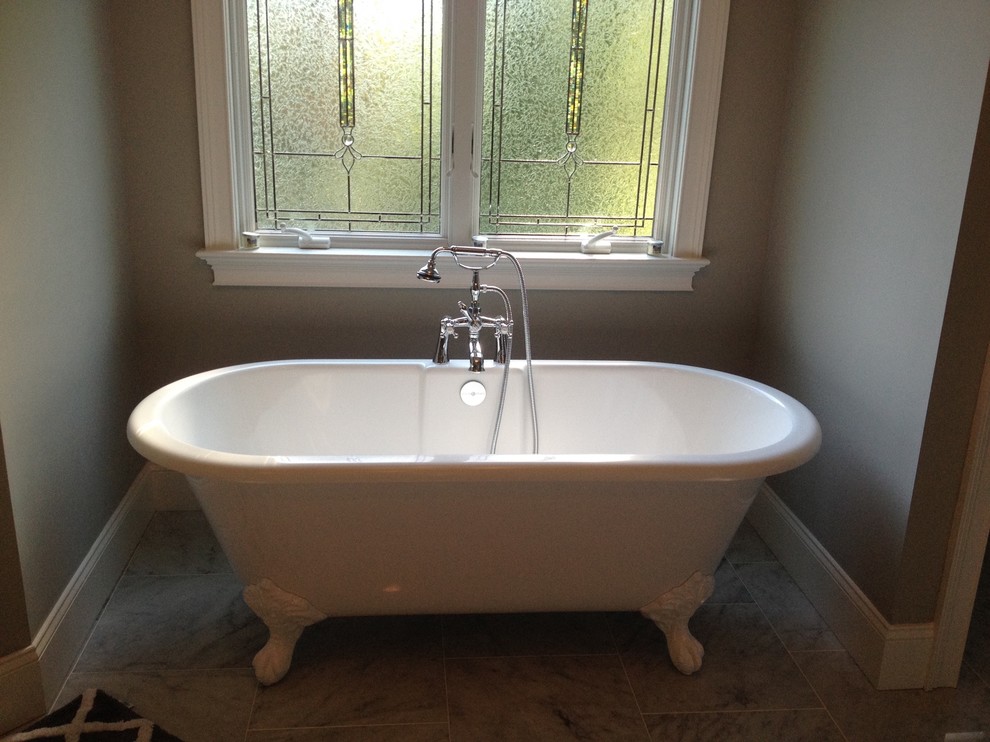 Imagen de cuarto de baño tradicional con bañera con patas, paredes grises, suelo de baldosas de porcelana y suelo gris