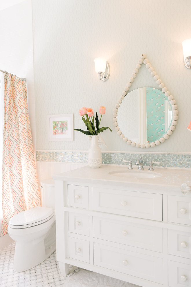Exempel på ett klassiskt badrum, med vita skåp, en dusch i en alkov, blå kakel, vita väggar, mosaikgolv, ett undermonterad handfat, dusch med duschdraperi och luckor med infälld panel