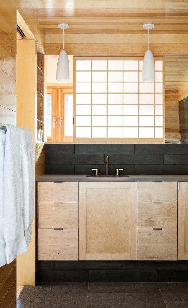 Idee per una stanza da bagno minimal con ante in legno chiaro e piastrelle nere