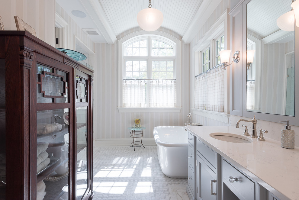 Klassisk inredning av ett en-suite badrum, med ett undermonterad handfat, skåp i shakerstil, grå skåp, ett fristående badkar och flerfärgade väggar