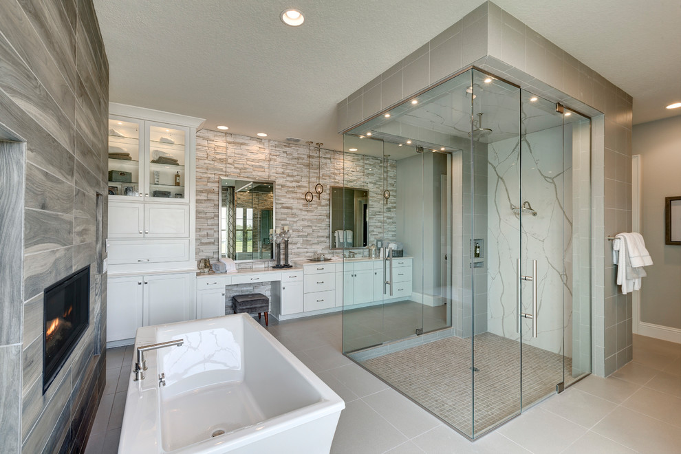 Пример оригинального дизайна: главная ванная комната в классическом стиле с фасадами в стиле шейкер, белыми фасадами, отдельно стоящей ванной, душем без бортиков, серой плиткой, белой плиткой, серыми стенами, серым полом, душем с распашными дверями и зеркалом с подсветкой